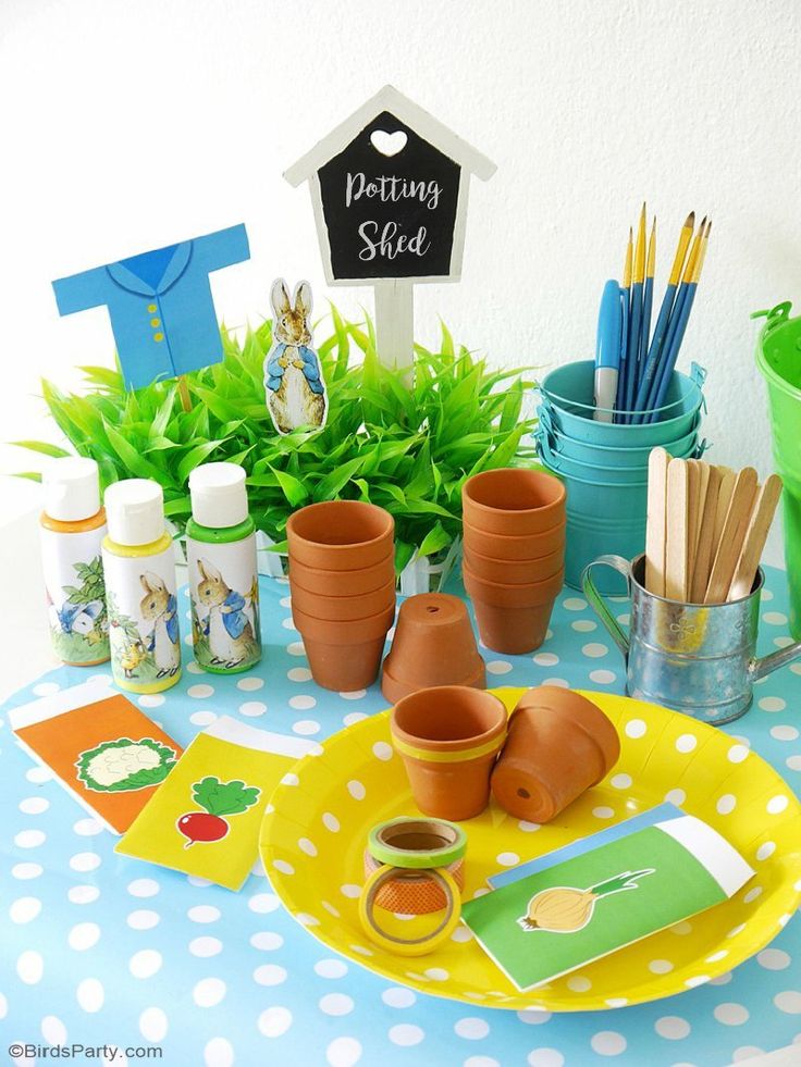 a table topped with lots of potted plants and other things on top of it