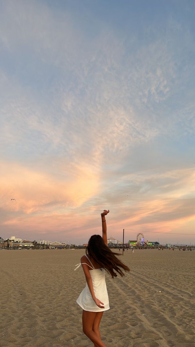 a girl is flying a kite on the beach