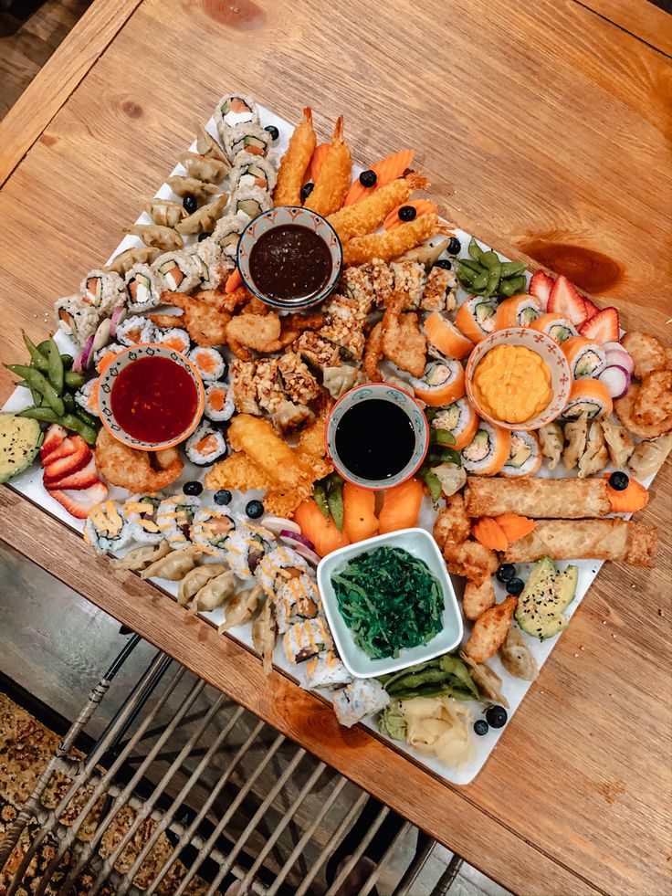 an assortment of appetizers and dipping sauces on a wooden table