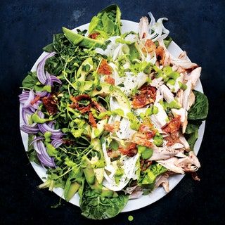 a white plate topped with salad and meat