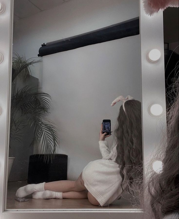 a woman taking a selfie in front of a mirror with her hair styled to look like a bunny