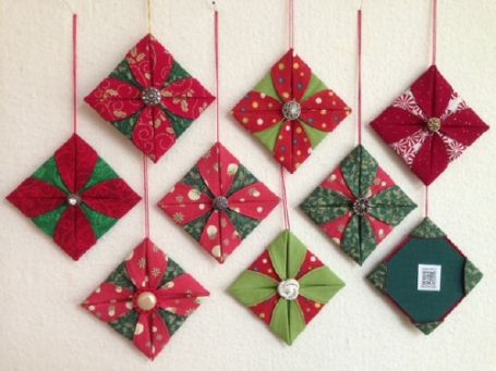 the ornaments are hanging on the wall and decorated with red, green and white ribbons