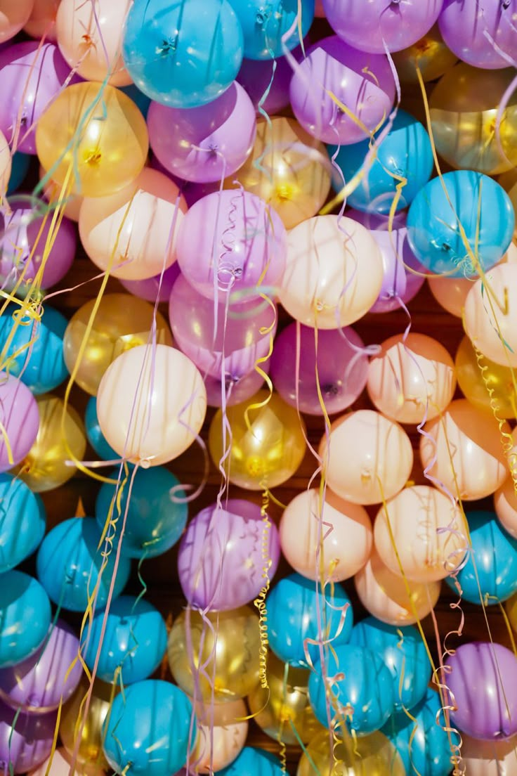 many different colored balloons are in the air