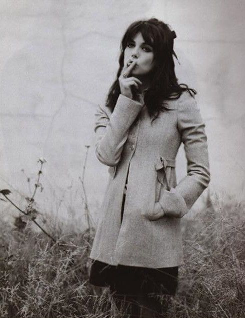 black and white photograph of a woman standing in tall grass with her hand on her mouth