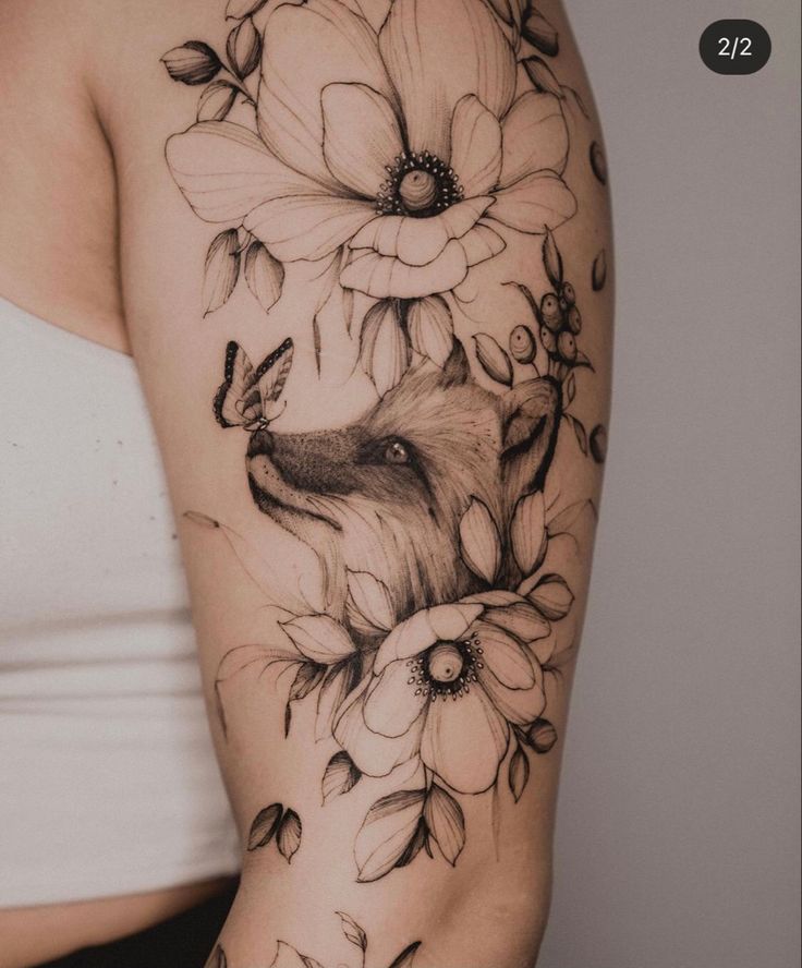 a woman's arm with flowers and a fox tattoo on the left side of her arm