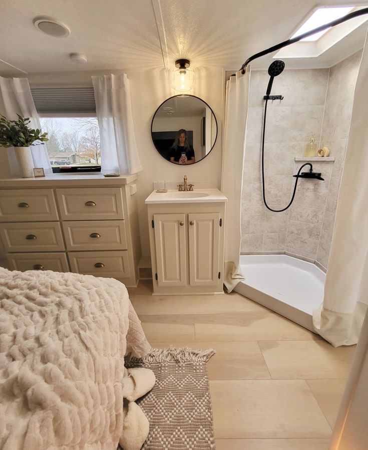 a bathroom with a sink, mirror and bathtub next to a shower stall that has a rug on the floor