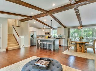 a living room filled with furniture next to a kitchen and dining room table on top of a hard wood floor