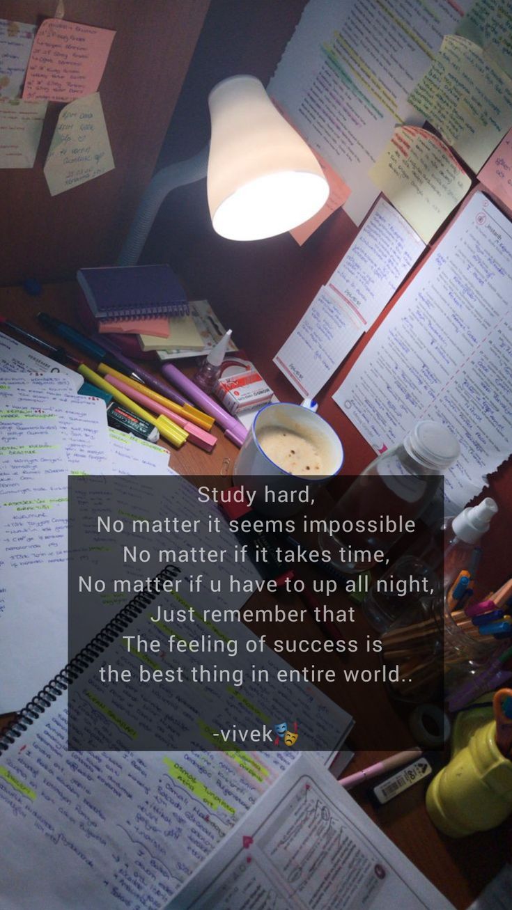 a desk with many papers on it and a lamp above the table that says study hard, no matter if seems impossible