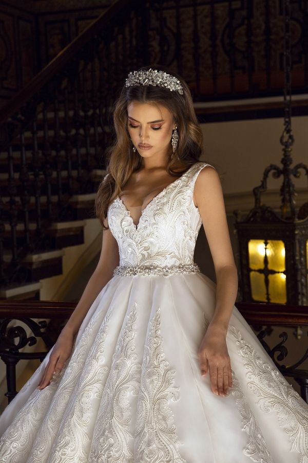 a woman in a wedding dress is standing on the stairs with her hand on her hip