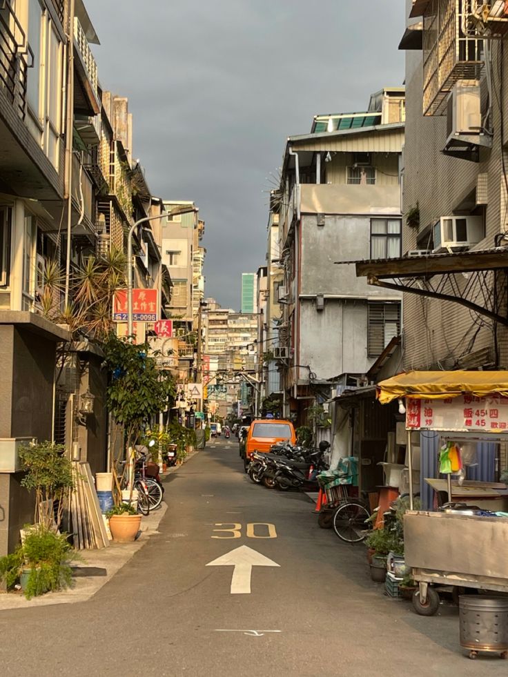 an empty street with buildings and parked motorcycles