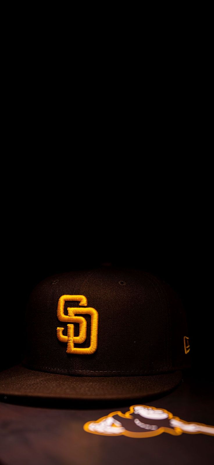 a baseball cap with the san diego padres logo on it sitting next to a bat