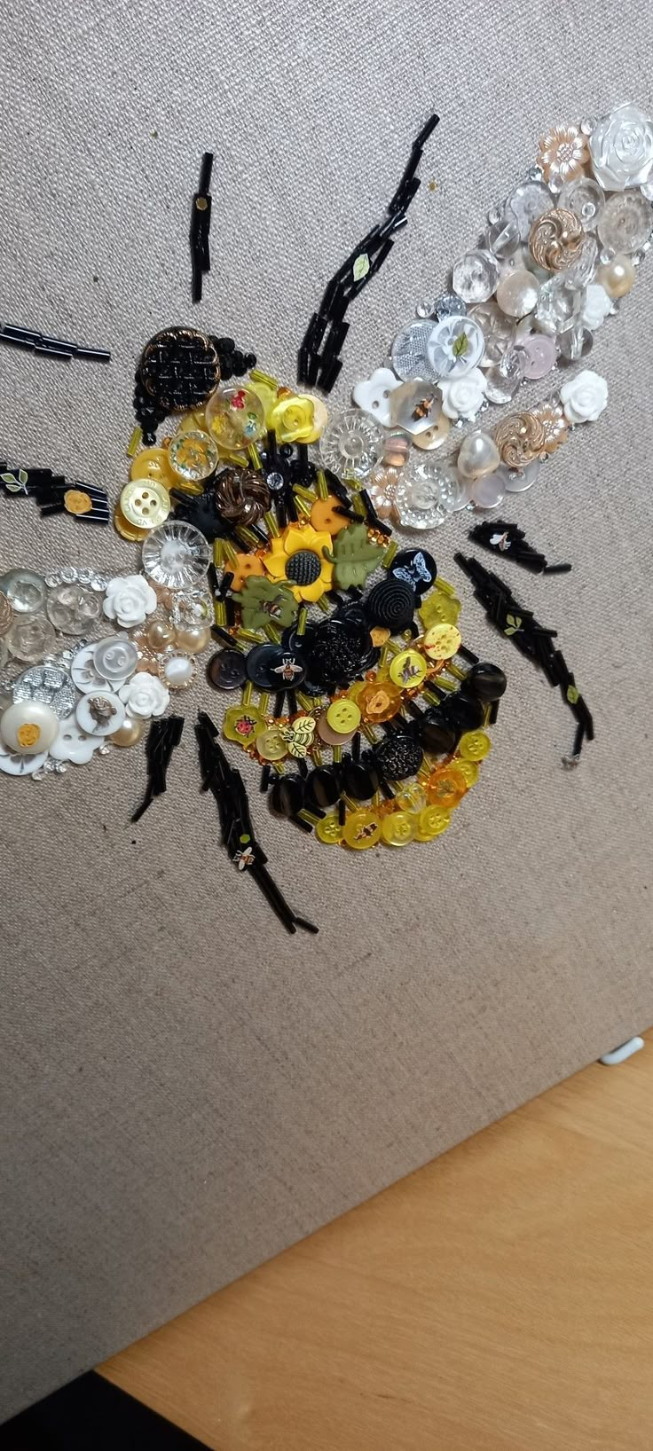 a bee made out of buttons sitting on top of a table