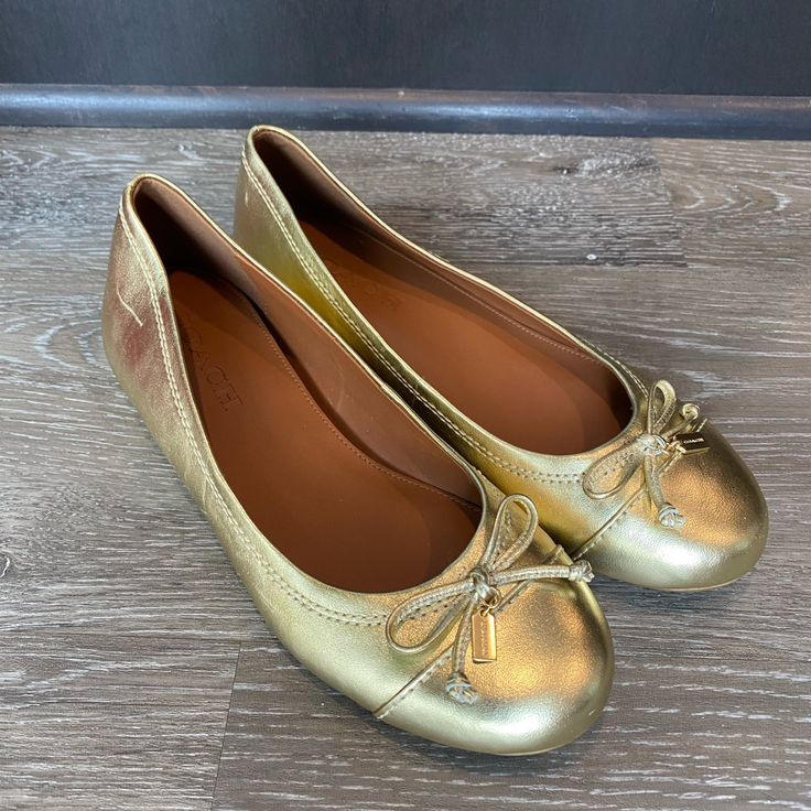 Brand New Casual Gold Synthetic Flats, Gold Flats With Cushioned Footbed, Gold Slip-on Flats With Cushioned Footbed, Gold Cushioned Slip-on Flats, Casual Gold Flats With Almond Toe, Chic Coach Spring Flats, Chic Coach Flats For Spring, Casual Gold Almond Toe Flats, Coach Spring Slip-on Flats