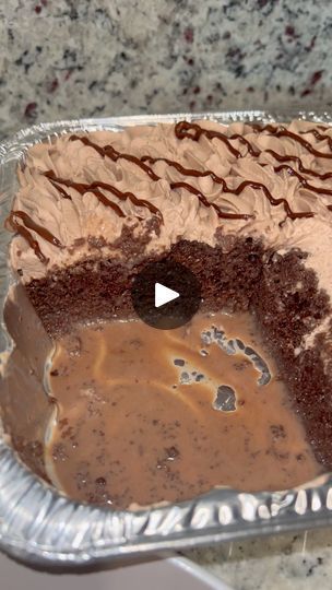 a piece of cake with chocolate frosting in a pan on a counter top next to a knife