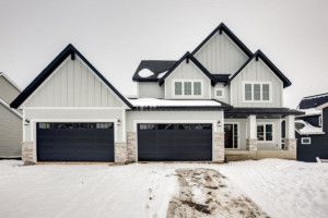 a large house with two garages and snow on the ground