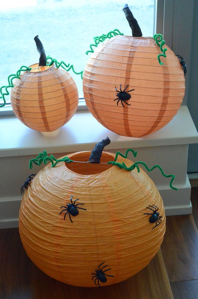 two paper pumpkins sitting on top of a window sill