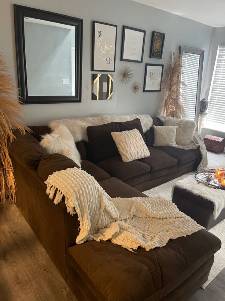 a living room filled with lots of furniture and pictures on the wall above it's couch