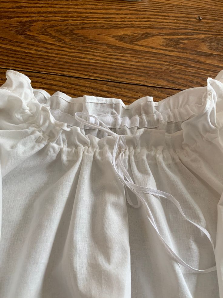 "This 18th century chemise is made out of bleached muslin and strung with 100% cotton twill tape. The length on the sleeve is 3/4. The length of this garment hits about mid thigh. They average about 40 inches in length. You can custom order this garment to your specifications, choose the long length custom option and send your requirements in \"notes to seller\". I use high quality muslin and twill tape for this item, it is made to last! These are custom made at the time of ordering, please let Spring Cotton Peasant Top For Gatherings, Summer Cotton Blouse For Gatherings, Cotton Peasant Top For Gatherings, Fitted Cotton Peasant Top Cottagecore Style, Fitted Cotton Peasant Top In Cottagecore Style, Peasant Cotton Blouse For Gatherings, Peasant Style Cotton Blouse For Gatherings, Cotton Ruffle Blouse For Gatherings, White Cotton Cottagecore Peasant Top