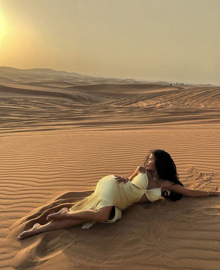 a woman laying on top of a sandy beach