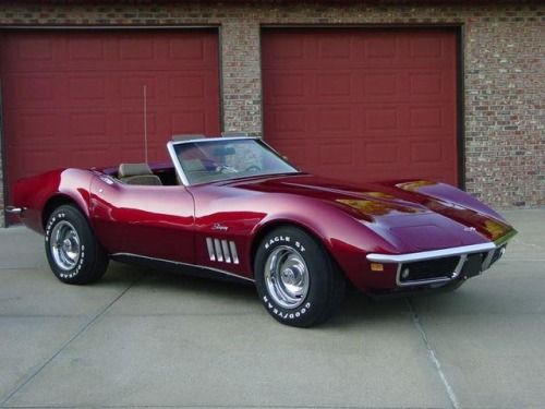 a red sports car parked in front of a garage door