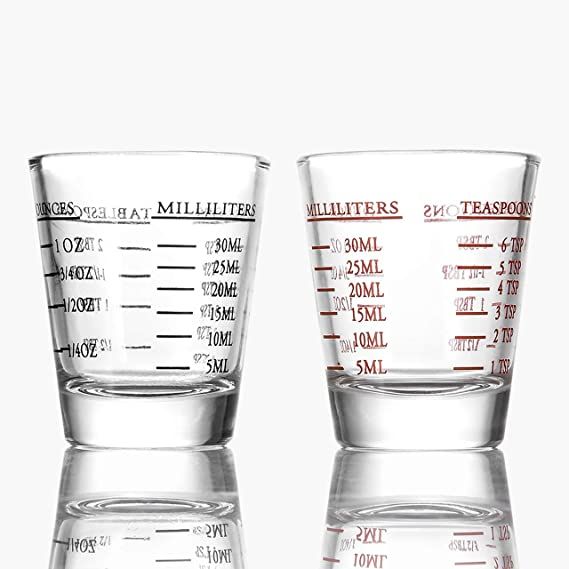 two measuring cups sitting side by side on top of each other in front of a white background