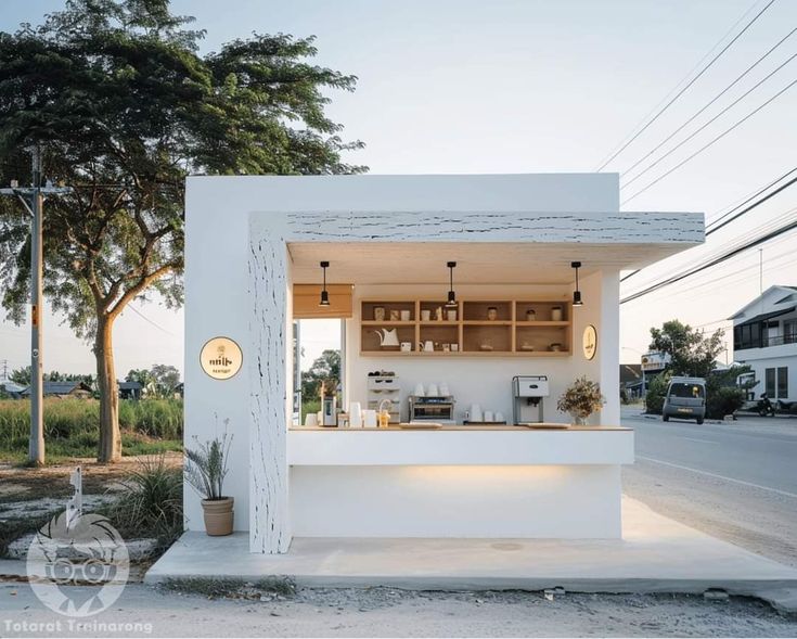 a small white building sitting on the side of a road