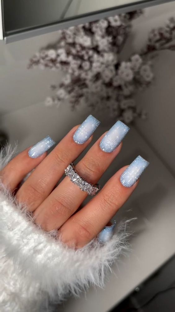 a woman's hand with blue and white manicures on it, next to a mirror