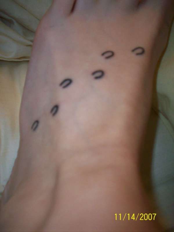 a person's foot with black dots on it