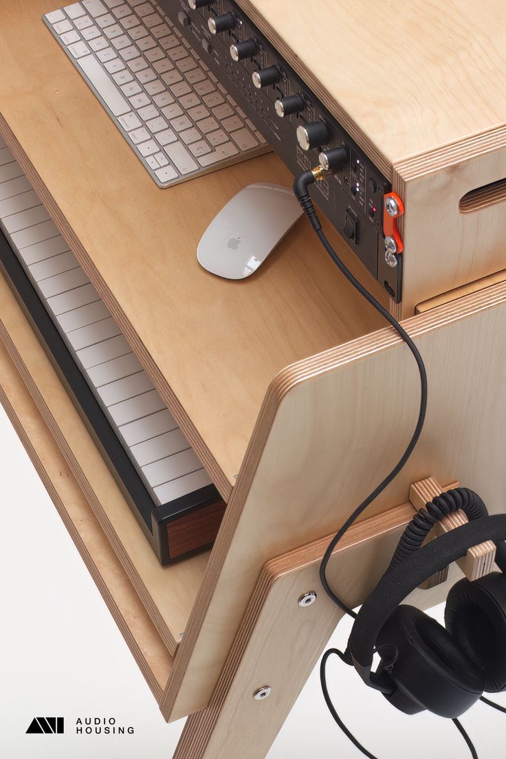 a computer keyboard and headphones on top of a wooden desk next to a mouse