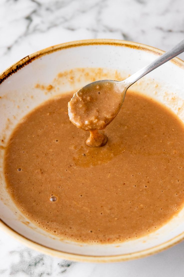 a spoon full of peanut butter in a bowl