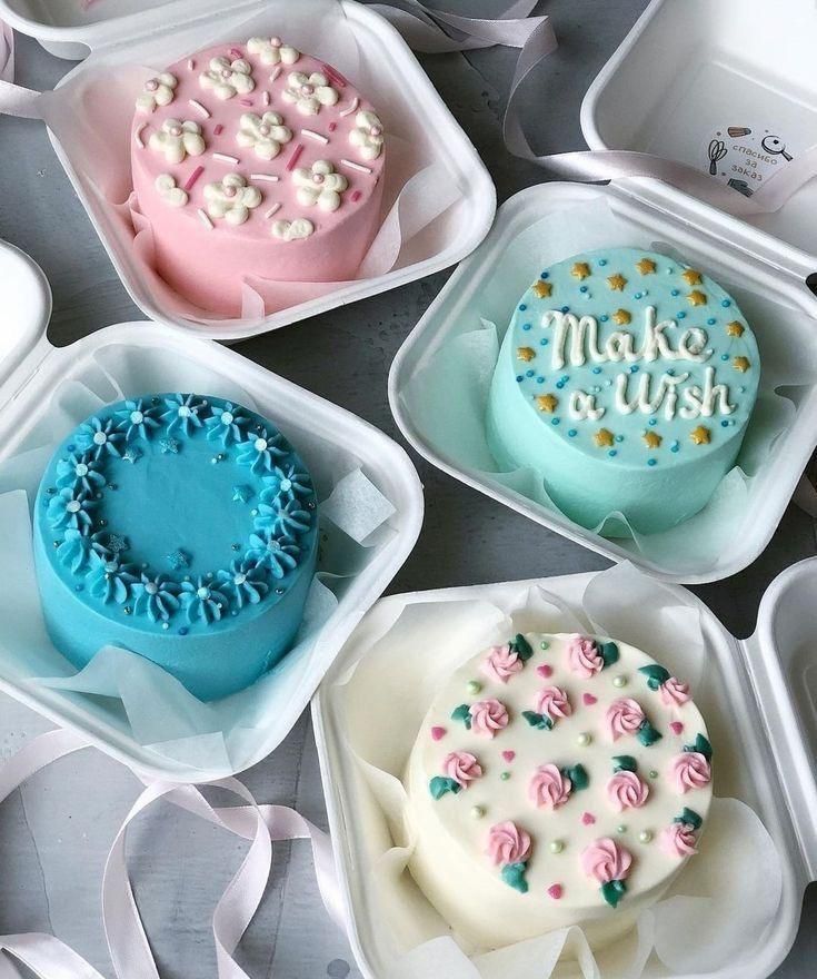 six decorated cakes in plastic containers on a table