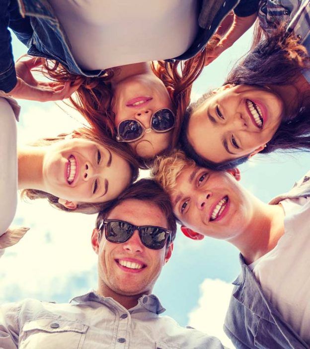 a group of people standing in a circle looking up at the camera with their eyes closed