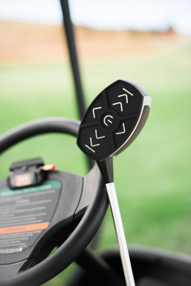 a steering wheel with an electronic device attached to it's center console in a golf cart