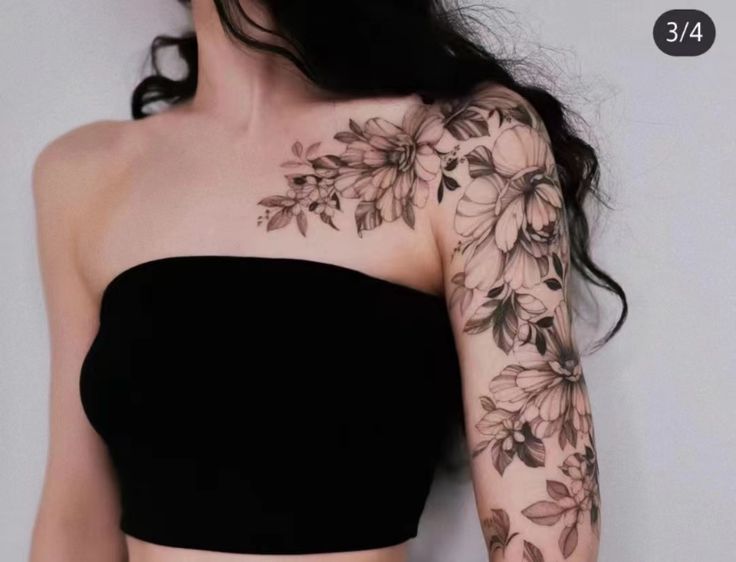 a woman wearing a black top with flowers on her arm