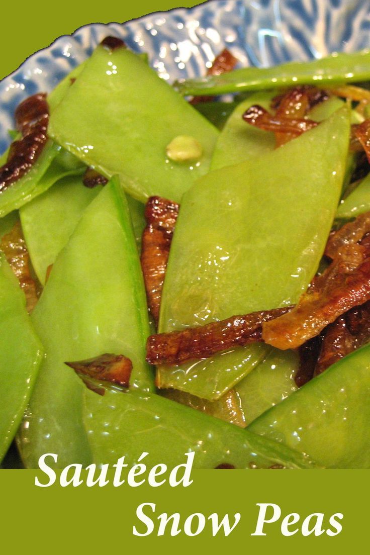 a blue and white plate topped with green beans covered in sauced snow pea seeds