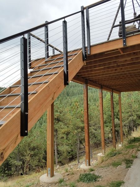 a wooden deck with metal railings and stairs