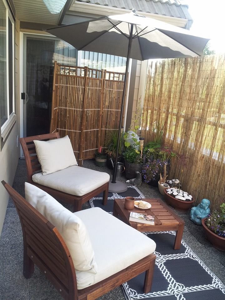 an outdoor patio with chairs, tables and umbrellas on the side of the house