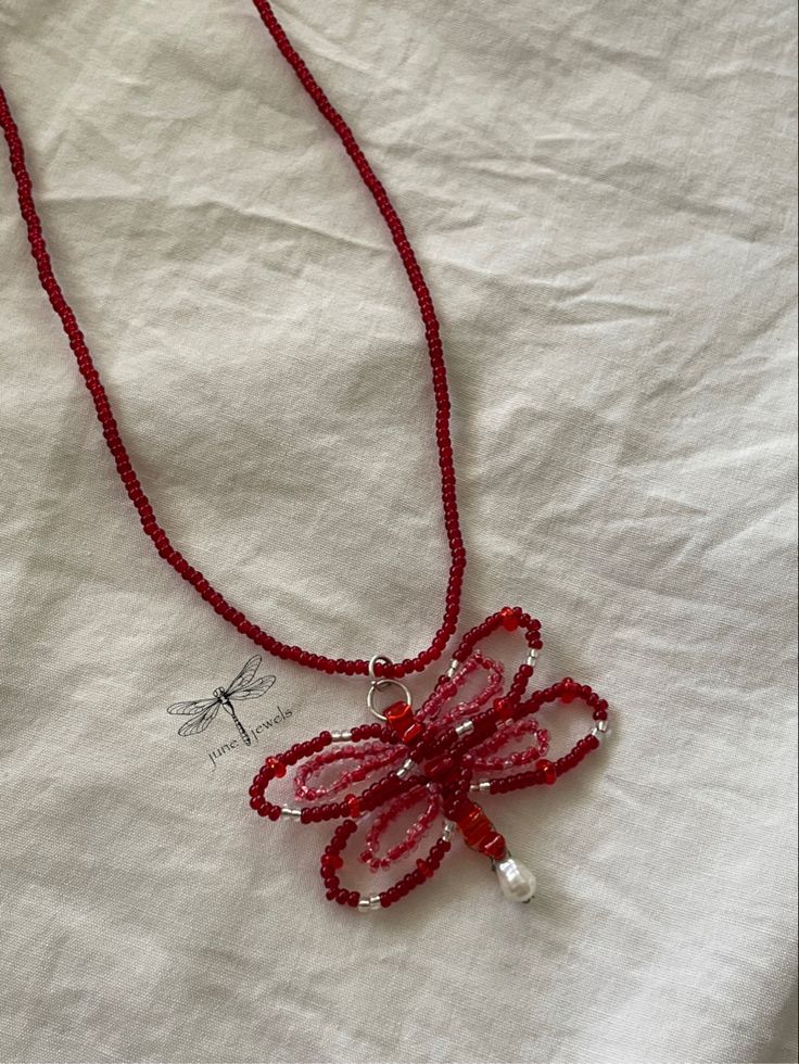 a red beaded necklace on a white sheet