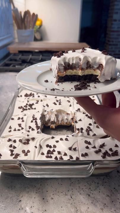 a person holding a piece of cake on a plate in front of the other one