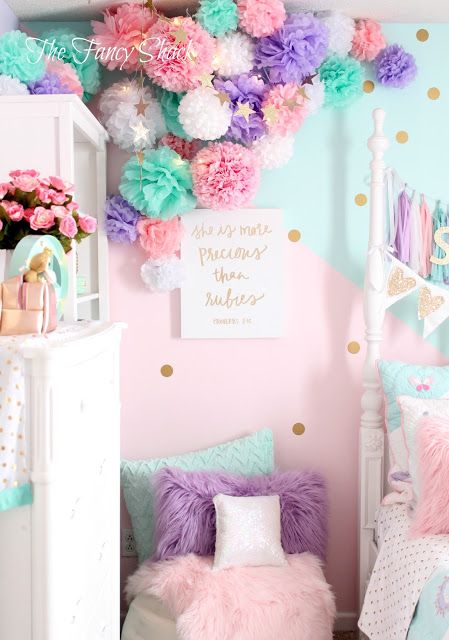 a pink and blue girls'bedroom decorated in pastel colors with pom poms