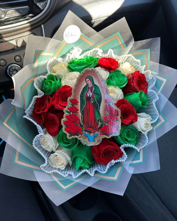 a bouquet of roses in the shape of a virgin mary on top of a car dashboard