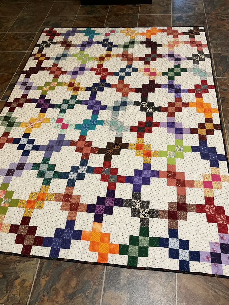 a multicolored quilt is laying on the floor