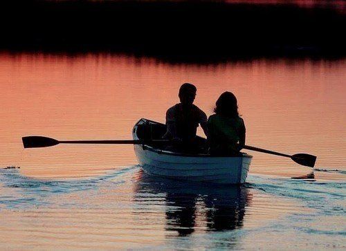 two people in a row boat on the water