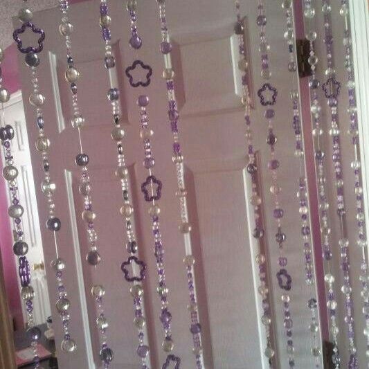 the door is decorated with purple beads and silver chains hanging from it's side