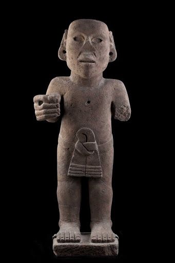 an ancient statue is shown against a black background with the image of a person holding something in his hand