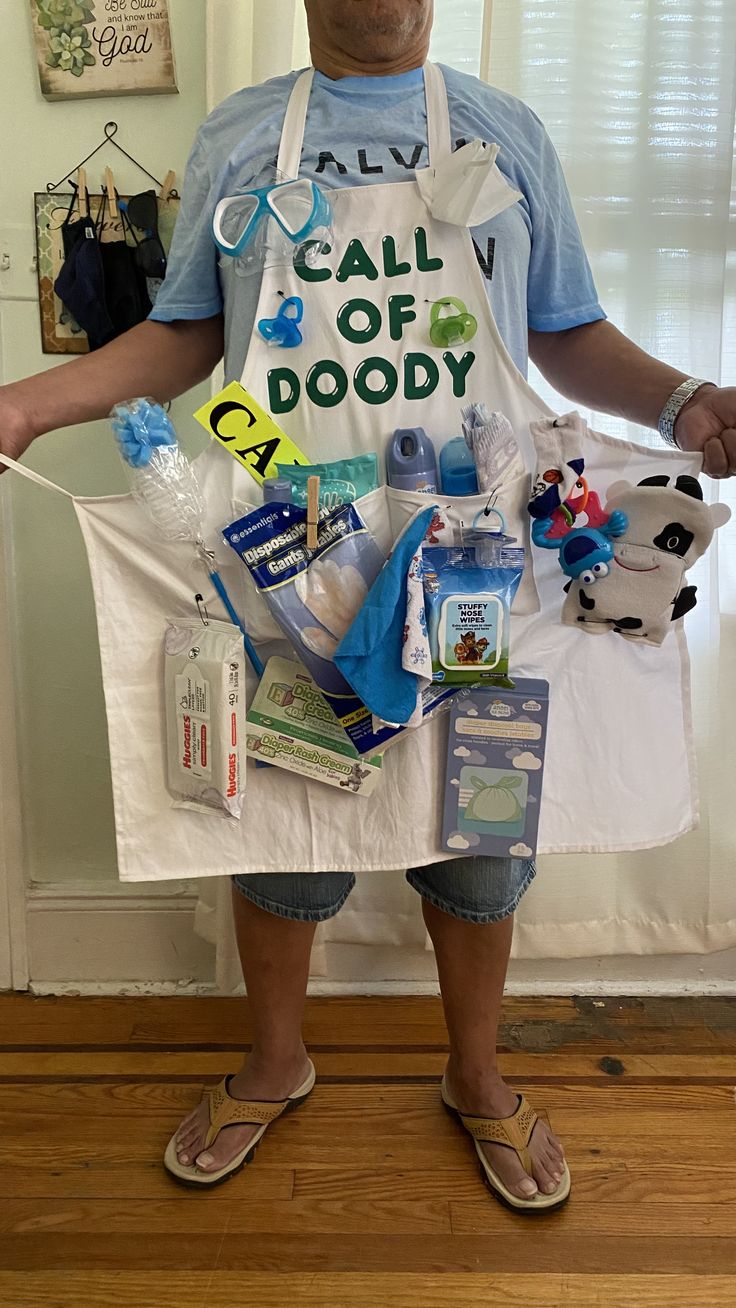 a man in an apron is holding items from his diaper line that includes baby products