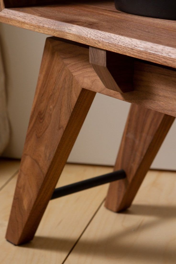 a close up of a wooden table with a black object on it's top