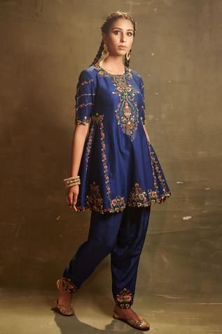 Royal blue kalidar top in dupion silk base featuring multi colored thread embroidery and embellished with cutdana, sequins and zardozi. Paired with dupion silk dhoti pant.
Component: 2
Embroidered
Neckline: Round
Sleeve Length: Elbow
Fabric: Dupion Silk
Color: Blue
Back keyhole button closure
Cutwork kurta hem - Aza Fashions Long Blouse Designs, Pant For Women, Desi Fashion Casual, Kurti Designs Party Wear, Suits Design, Embroidery Suits Design, Dupion Silk, Dress Indian Style, Organza Dupatta