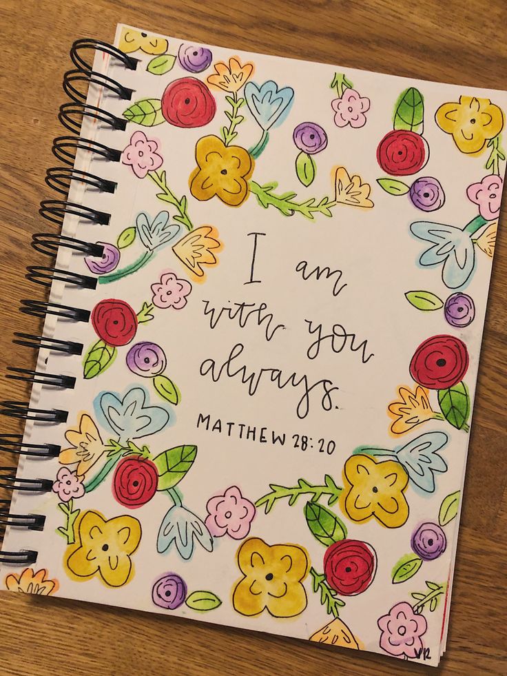 a spiral notebook with the words i am with you always written in flowers on it