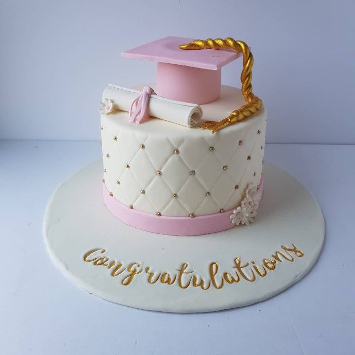 a cake with a graduation cap and diploma on top that says congratulationss in gold lettering